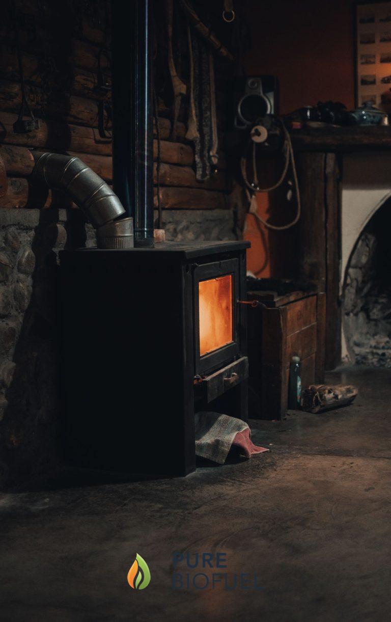 Rustic wood-burning stove with a bright fire against a brick wall